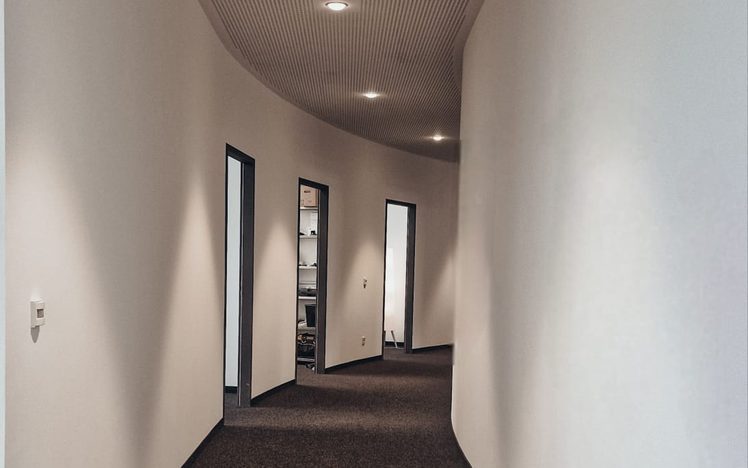 Geschwungener Bürogang mit Akustikdecke und Teppichboden