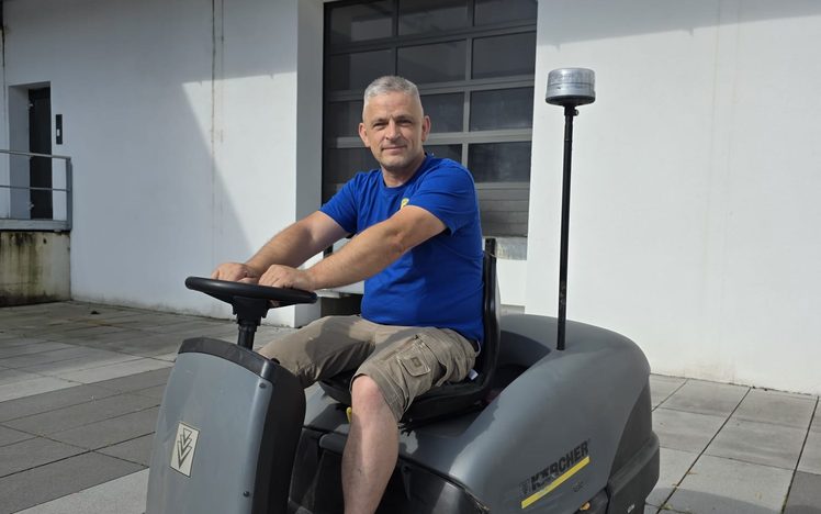 Mitarbeiter auf der Kehrmaschine im Innenhof